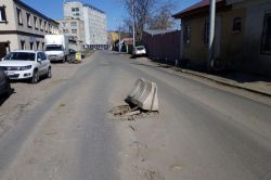 Выбоины и разрушенные люки мешают движению по улице Крайней